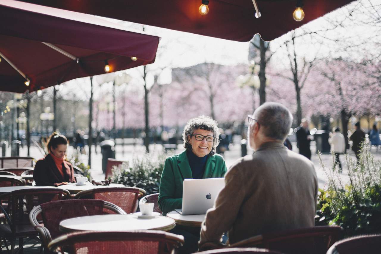 Two people sitting working outdoors at a cafe in Kungsträdgården, Stockholm